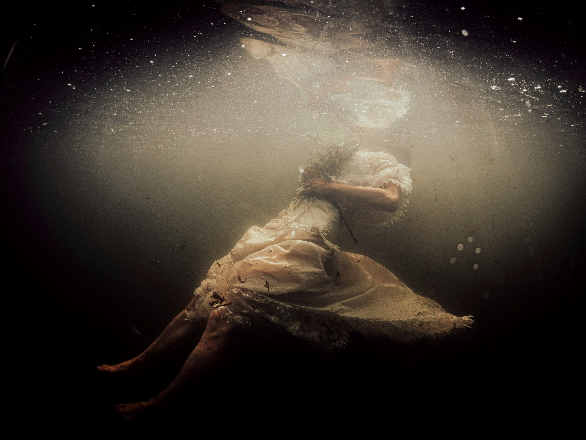 a woman in a white dress under water