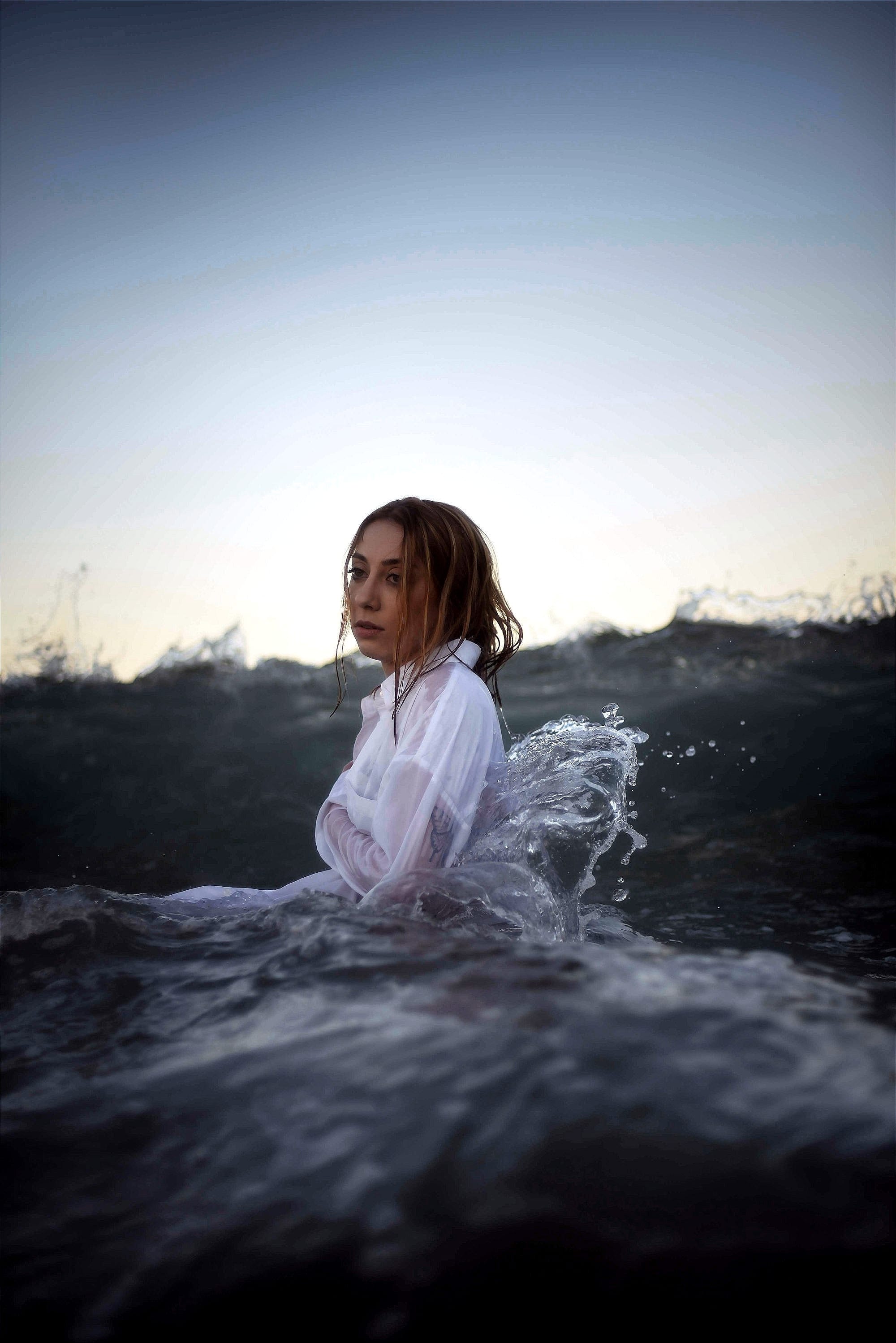 a woman sitting on a surfboard in the ocean